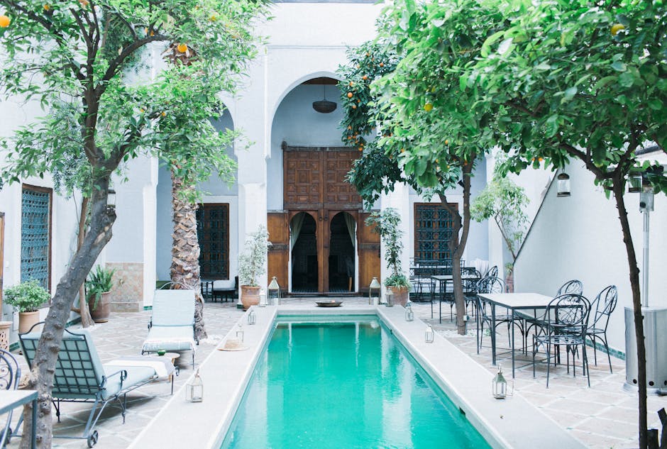 Exterior of patio with wooden doorway and tangerine trees near swimming pool and furniture